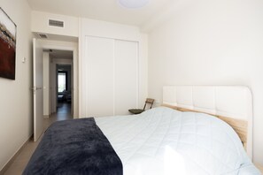Ein Schlafzimmer mit einem Bett, einem Kleiderschrank und einer Tür zu einem anderen Raum.