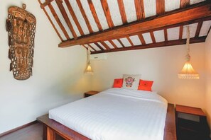 Un dormitorio con una cama de madera, ropa de cama blanca y un adorno en la pared.
