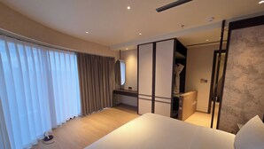 A hotel room with a large bed, a wardrobe, a mirror, and a view of the outdoors. - DUHORÉA hotel and wellness (Hanoi)