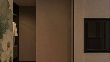A modern hotel room with a large bed, a TV mounted on the wall, and a sliding door leading to a bathroom.