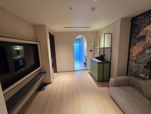 Una sala de estar moderna con un televisor de pantalla plana, un sofá y una mesa de centro.
