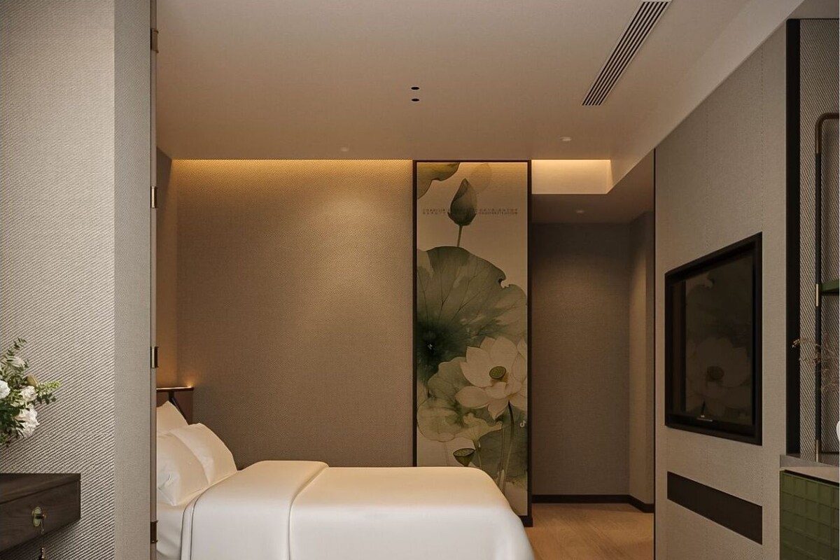 Un dormitorio moderno con cama, mesita de noche, televisor montado en la pared y una obra de arte floral grande.