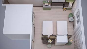 Une chambre d’hôtel de taille réduite, comprenant un lit, un petit bureau, une chaise, des toilettes et une fenêtre.