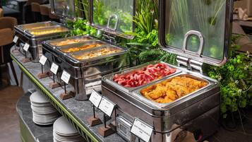 Un bufé con diversas opciones de comida, incluyendo opciones fritas crujientes y carne roja.