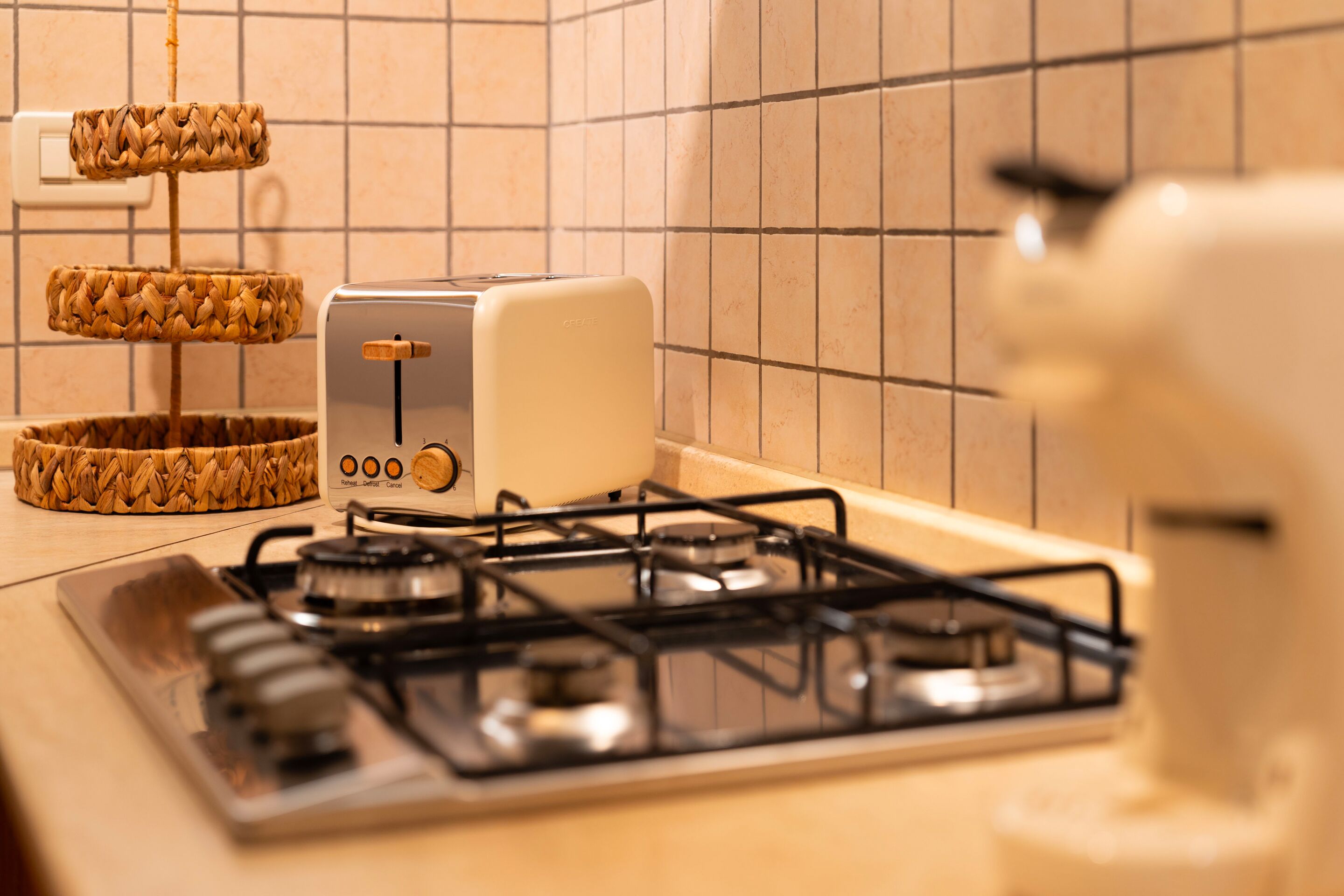 Eine Küche mit Gasherd, Toaster und einem gewebten Korb auf der Arbeitsfläche.