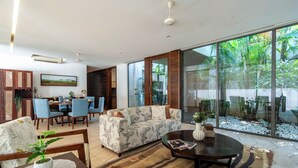 A spacious living area with a sofa, coffee table, and dining set. - Staymaster Belamia•3BR•Private Pool (Parra)