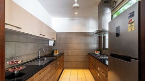 A modern kitchen with a stainless steel refrigerator, a double sink, and wooden cabinets. - Staymaster Belamia•3BR•Private Pool (Parra)