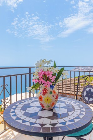 A round table with a mosaic tile design, a vase with flowers, and a view of the sea. - Villa Mamma Mia, Luxury Villa with Panoramic Sea Views (Salobreña)