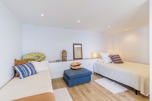 A room with two beds, a small table, a mirror, and a wall-mounted light fixture. - Villa Mamma Mia, Luxury Villa with Panoramic Sea Views (Salobreña)