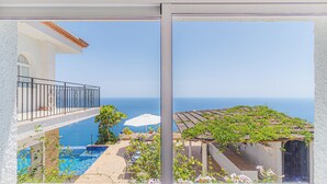 Ein Balkon mit Pool, Essbereich und Meerblick.