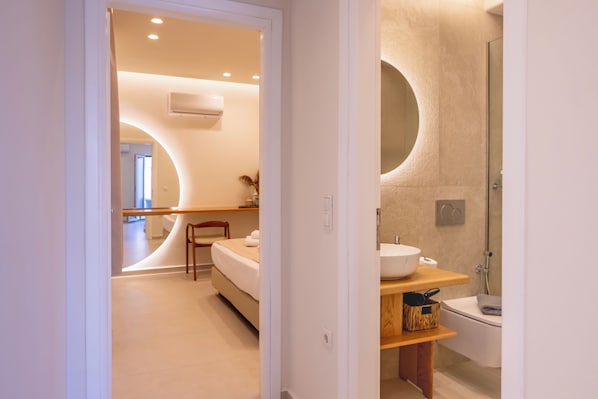 A modern bathroom with a bathtub, a sink, and a mirror. - GuVer Luxury Suites (Naxos)
