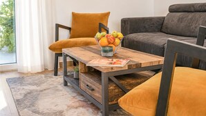 Ein Wohnzimmer mit Couch, Sessel und einem Holztisch.