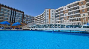 A hotel with a pool, multiple balconies, and a covered walkway. - Modern Studio Apartment With Stunning Red Sea Views (Hurghada)