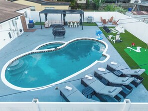 Um quintal com piscina, área de estar externa e um espaço de varanda.