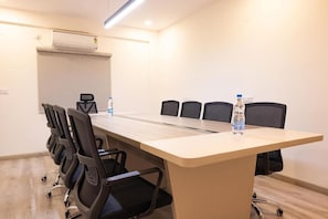 A conference room with a long table, six chairs, and two water bottles on the table. - Hotel Radhe Pride  (Hyderabad)