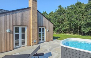 A modern house with a swimming pool, a patio with a lounge chair, and a brick chimney. - Gorgeous home in Grenaa with sauna (Grenaa)