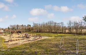 Ein Spielplatz mit Schaukeln, Rutschen und einem Sandkasten.