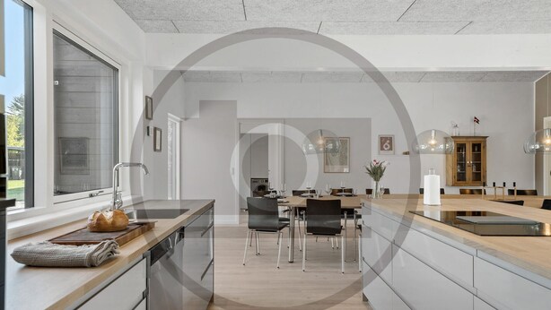 A modern kitchen with a central island, dining area with chairs, and a view of the outdoors. - Stunning home in Fårvang with sauna (Fårvang)