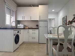 Eine moderne Küche mit Waschmaschine, Mikrowelle und Kühlschrank.