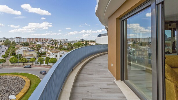 A balcony with a curved railing overlooking a residential area with houses and a clear sky. - Sky Garden Jerez - Ole Solutions (Jerez de la Frontera)