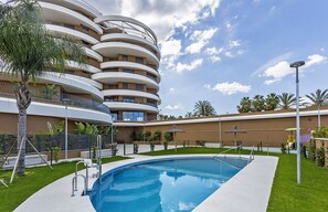 A modern hotel with a circular building, a swimming pool, and a well-maintained lawn. - Sky Garden Jerez - Ole Solutions (Jerez de la Frontera)