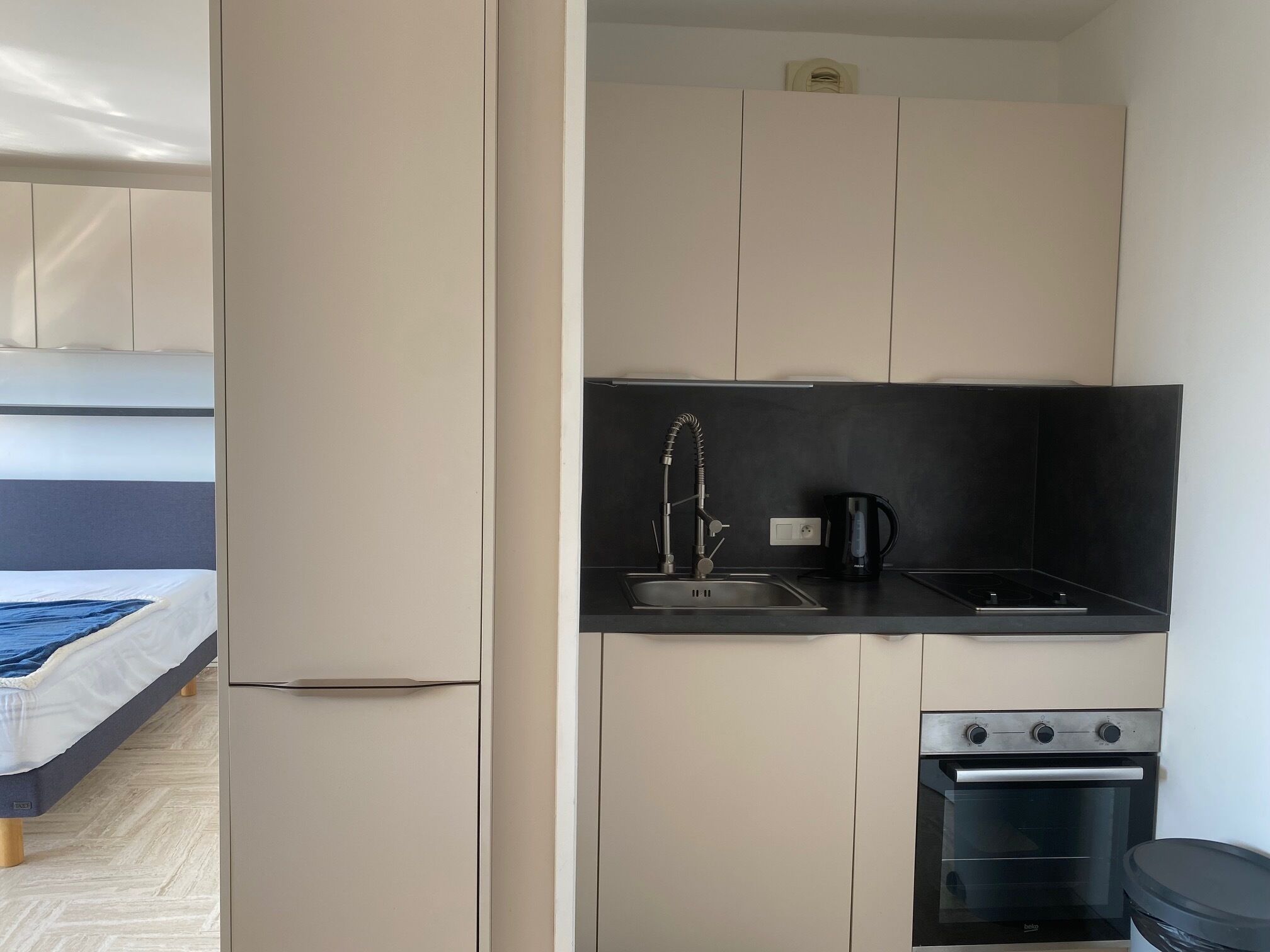 A compact kitchenette with a sink, stove, and a small oven.