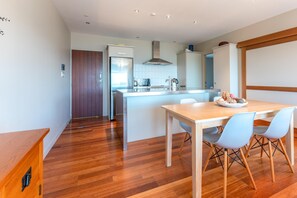 Eine moderne Küche mit einer Holztischinsel, Edelstahlgeräten und einem Essbereich mit Tisch und Stühlen.