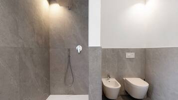 Un baño moderno con ducha, bidé y retrete.