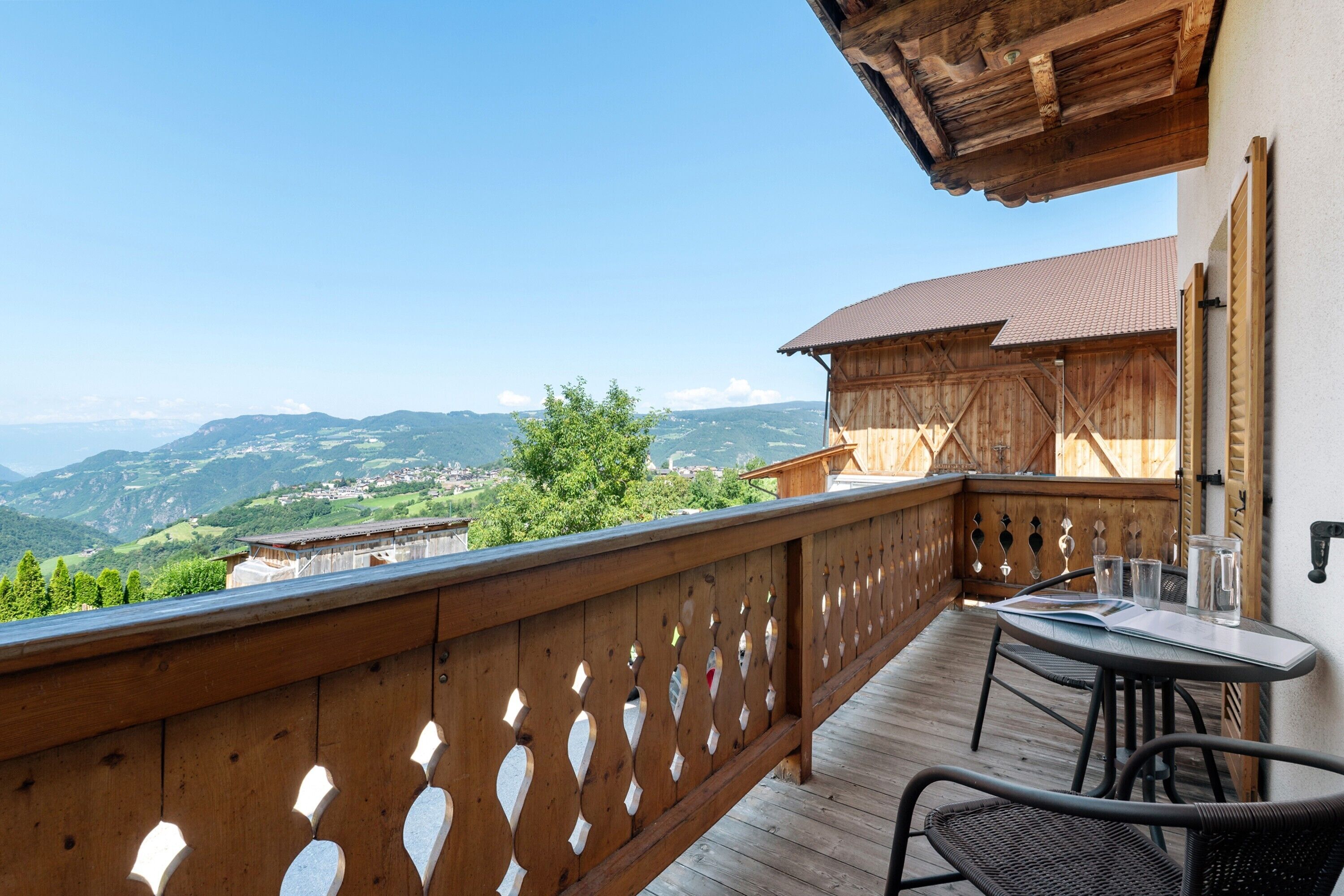 Un balcon en bois offrant une vue sur un paysage montagneux.