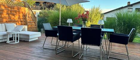 Una terraza con una mesa de comedor, sillas y un sofá.