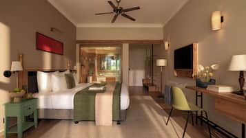 A hotel room with a bed, bedside table, desk, chair, and a ceiling fan.
