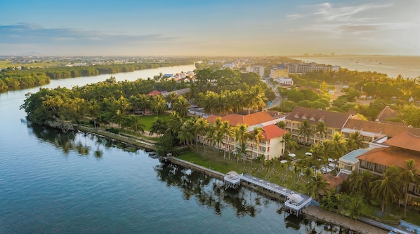 A coastal hotel with a waterfront view, a dock, and a landscaped garden.