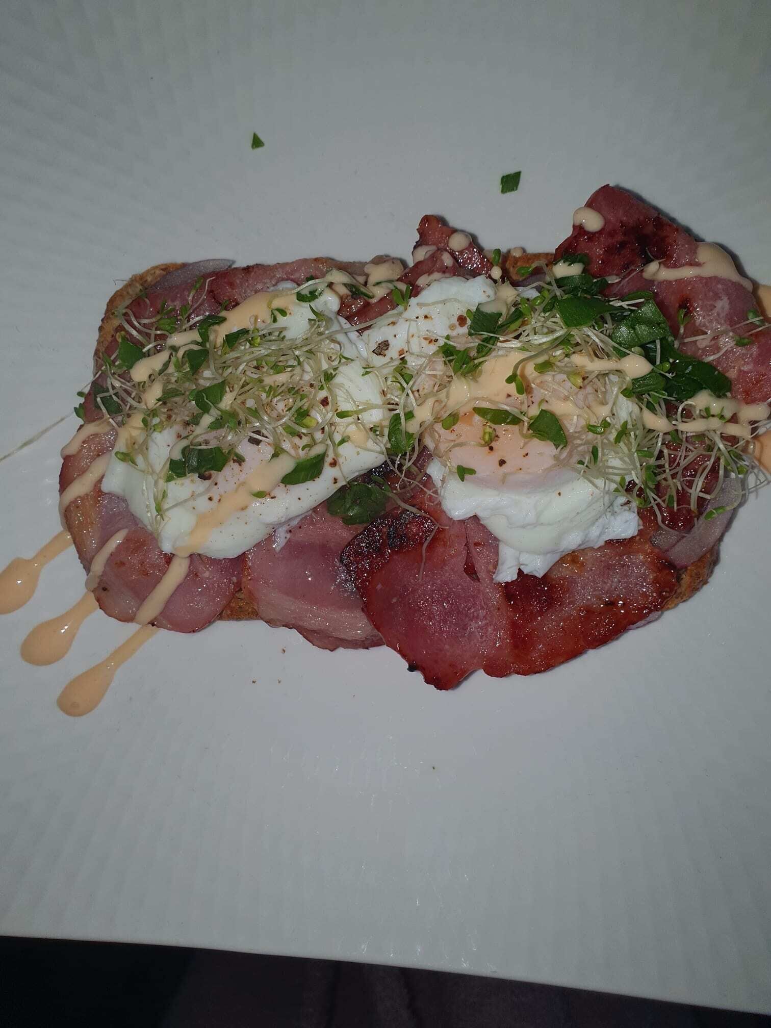 Un plato con un guiso de carne, huevos y verduras, con salsa por encima.