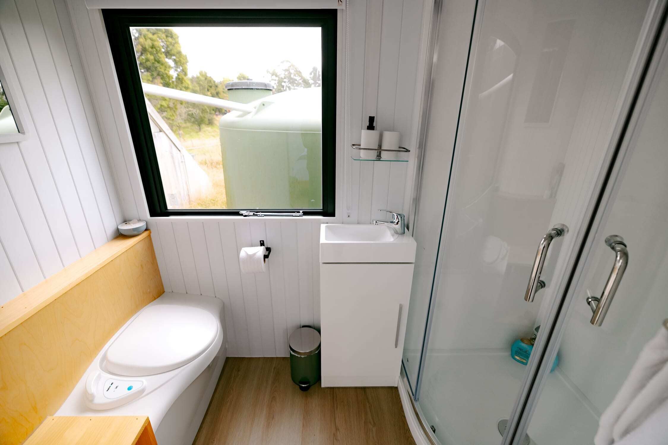 A compact bathroom with a toilet, sink, and a window.