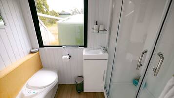A compact bathroom with a toilet, sink, and a window.