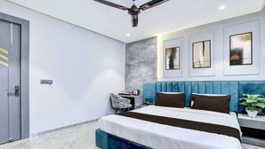 A modern bedroom with a large bed, a ceiling fan, a nightstand, and a wall-mounted TV. - Suite Room Clubhouse Vytilla Kochi (Kanayannur)