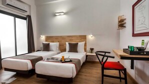 A hotel room with two beds, a desk, a chair, and a window. - Suite Room Clubhouse Vytilla Kochi (Kanayannur)