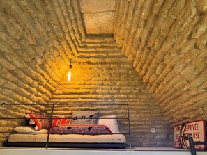 A bunk bed in a stone-walled room with a single hanging light fixture. - Les Cinq Bories - An Exceptional Estate Just a 10-Minute Walk from the Village of Gordes (Gordes)