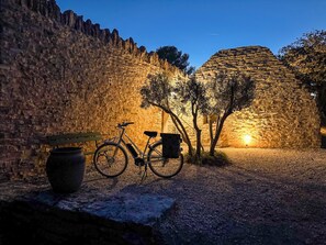 A stone wall, a bicycle, a bench, and a large pot. - Les Cinq Bories - An Exceptional Estate Just a 10-Minute Walk from the Village of Gordes (Gordes)