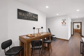 Eine moderne Bar/Lounge-Bereich mit einem Holztisch, Stühlen und einem Schild für Walnut Peak Bar & Lounge.
