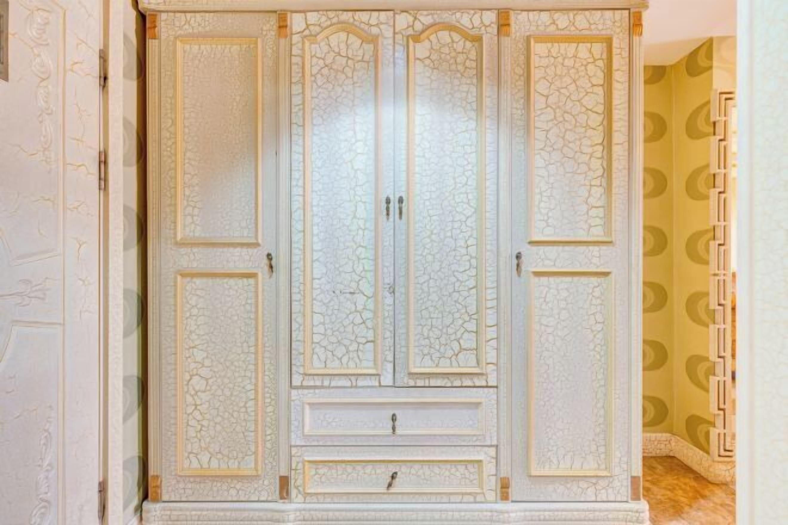 Un armario grande y decorativo con varias puertas y cajones.