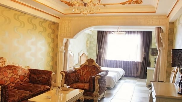 A hotel room with a sofa set, a coffee table, a bed, and a television. - Manzhouli Junyu Grand Hotel (Manzhouli Wanda Plaza Matryoshka Square) (Manzhouli)