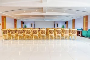A conference room with a long table and chairs, a green tablecloth, and a Christmas tree.