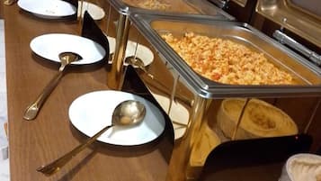 Una mesa de buffet con múltiples fuentes y utensilios.