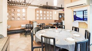 Un espace repas avec des tables rondes, des nappes à carreaux noirs et blancs et des chaises noires.