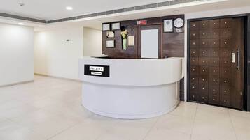 A reception desk with a sign reading 'PALETTE & Company Services,' a clock, framed certificates, and a door with a metal grid pattern.