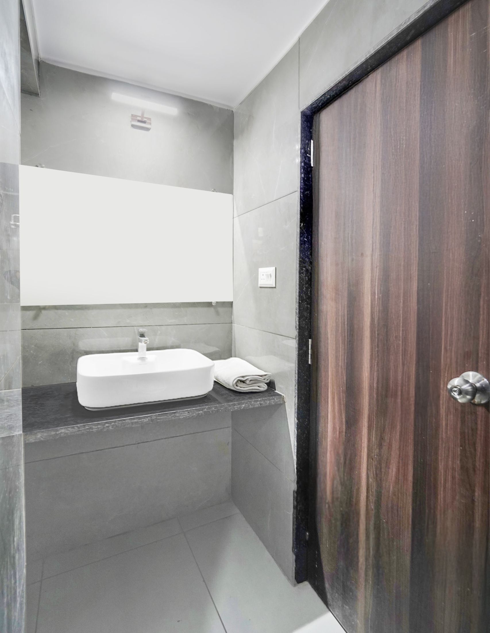 A bathroom with a white sink, a towel, and a wooden door.