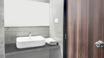 A bathroom with a white sink, a towel, and a wooden door.