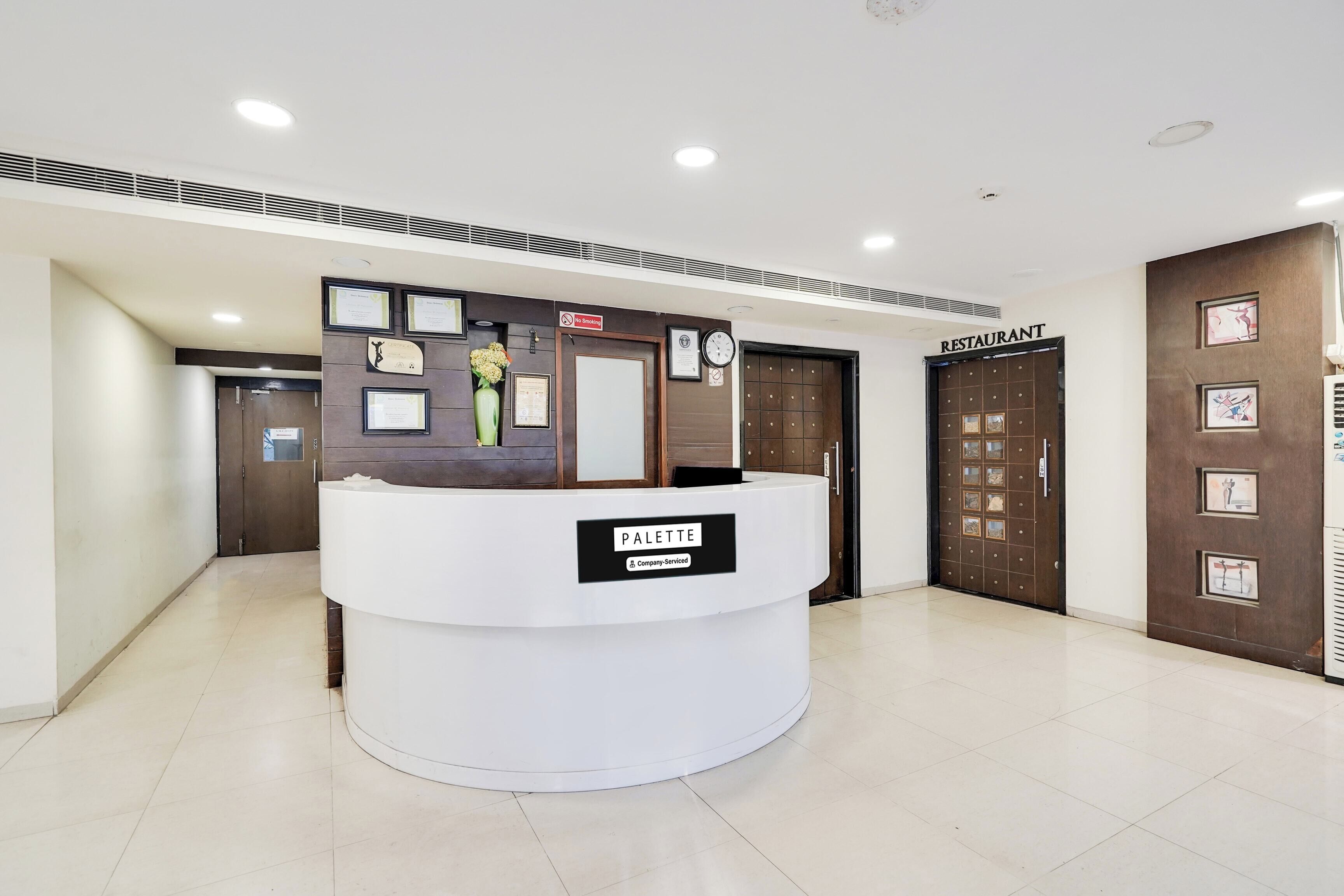 Un mostrador de recepción con un letrero que indica 'Company Serviced' y un cartel de 'No Fumar' sobre la puerta.