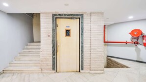 A hotel entrance with a marble staircase leading to a lift door marked 'LIFT'. - Palette Country Club Surat (Surat)